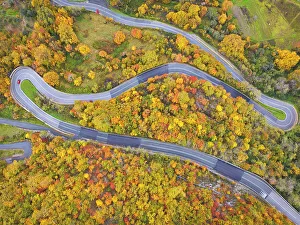 Autumnal Prints: A car driving along the mountain road on an autumn day