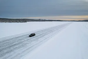 Lapland Prints: Car on icy road on a frozen lake from above
