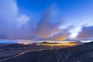 Freeways Prints: Car trail lights on desert road crossing the barren land at dusk, Vallebron lookout