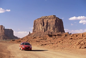 Motorcar Prints: Car on valley drive road beneath Merrick Butte
