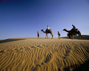 Caravan of people and camels in the Thar Desert