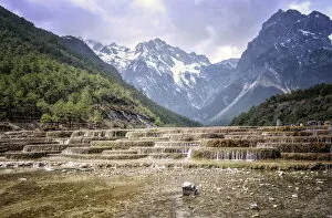Flowing Gallery: Cascading falls at Baishuihe with Jade Dragon Snow Mountain backdrop, Lijiang, Yunnan, China, Asia