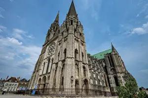 Towers Prints: Cathedral of Chartres shows tall towers and intricate stonework under blue sky in France