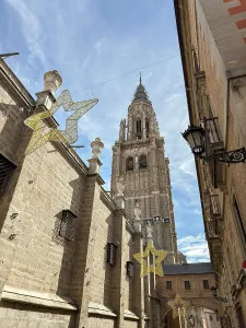 Stars Prints: Cathedral tower stands tall above narrow street adorned with decorative stars in Toledo