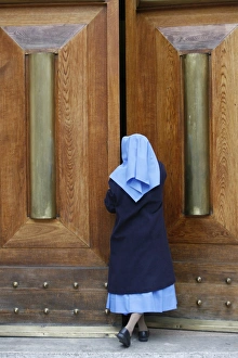 Opening Prints: Catholic nun opening a door, Rome, Lazio, Italy, Europe