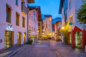 Chalet Prints: Chalet hotel and museum in Zell am See at dusk with visitors walking on the street in Salzburg