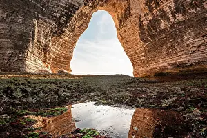 Eroded Prints: Chalk arch reveals English Channel at Etretat cliffs in Normandy during low tide