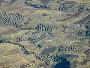 Sustainable Prints: Charter flight view over terraced farmlands in Madagascar during journey to Antanavarino Charter Flight Base