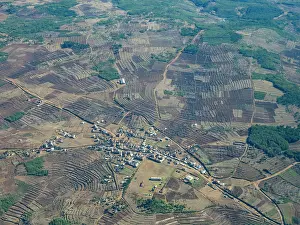 Small Prints: Charter flight view over a village in Madagascar showcasing farmland and rural landscape during daytime