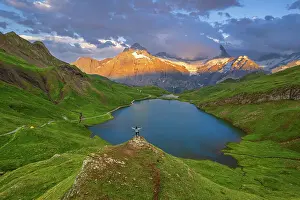 Adults Prints: Cheerful hiker overlooking Bachalpseee admiring the sunset over Bernese Oberland mountains