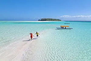 2 People Prints: Cheerful man and woman having fun chasing each others on a tropical beach
