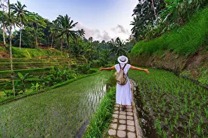 Farmer Prints: Cheerful woman with arms outstretched standing on footpath amidst paddy fields