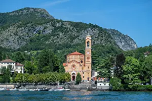 Clock Prints: Chiesa San Lorenzo stands by the lake under the mountain at Lenno in Italy on a clear day