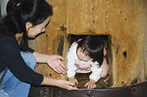 Child crawling though hole in wooden column to reach Nirvana