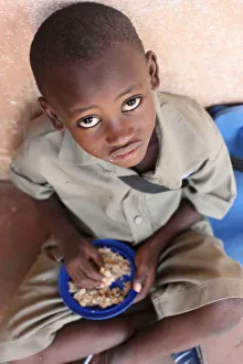 One Boy Only Prints: Child eating a meal in a primary school in Africa, Lome, Togo, West Africa, Africa