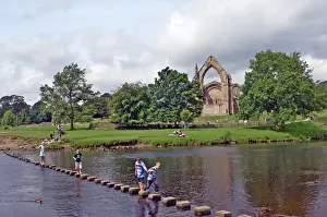 Children Prints: Children crossing the stepping stones across the river Wharfe at Bolton Abbey