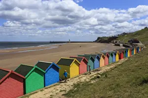 Multi Coloured Prints: Children kick football near colourful beach huts above West Cliff Beach