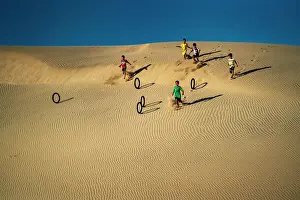 Outdoor Activities Prints: Children rolling tyres as hoops down the Nam Cuong sand hill in Ninh Thuan