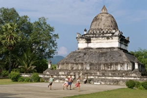Children run in front of the Lotus Stupa at the Vixoun