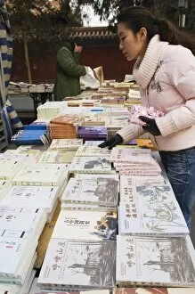Images Dated 2nd January 2008: A Chinese girl looking for books at Ditan Park book fair, Beijing, China, Asia