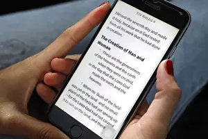Females Prints: Christian woman reading a digital Bible in English on a smartphone, Vietnam, Indochina
