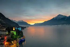 Lake Como Prints: Christmas lights decorating the old bell tower and houses in Gravedona during sunrise