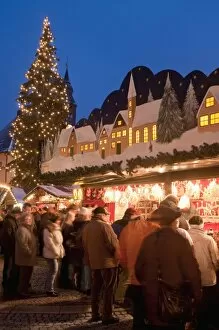 Christmas Market with decorated stall, people and Christmas tree at twilight