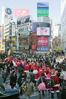 Images Dated 19th December 2009: Christmas Santas walking across Shibuya crossing, Shibuya ward, Tokyo, Japan, Asia
