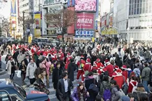 Images Dated 19th December 2009: Christmas Santas walking across Shibuya crossing, Shibuya ward, Tokyo, Japan, Asia