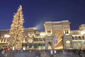Christmas tree and Galleria Vittorio Emanuele entrance illuminated at dusk