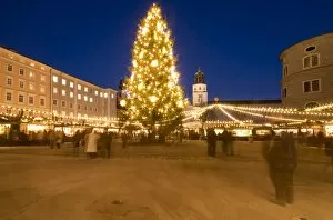 Christmas tree and stalls of historical Salzburg Christkindlmarkt (Christmas market) with Glockenspiel building