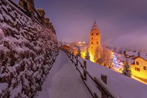 Snowflakes Prints: Church of Saint Pantalon and snow covered town centre and mountainous background in winter at dusk