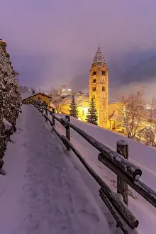 Snowfall Prints: Church of Saint Pantalon and snow covered town centre and mountainous background in winter at dusk