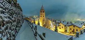 Snowfall Prints: Church of Saint Pantalon and snow covered town centre and mountainous background in winter at dusk
