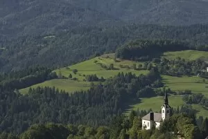 Church standing in valley of vast hill landscape, Sofja Loka, Slovenia, Europe