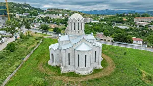 Traditions Prints: Church structure stands in Shuhsa surrounded by green land and buildings in Qarabaqh region of Azerbaijan