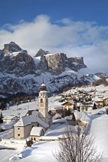 The church and village of Colfosco in Badia, 1645m, and Sella Massif range of mountains under winter snow, Dolomites, South Tirol, Trentino-Alto Adige
