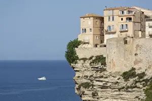 The Citadel and old town of Bonifacio perched on rugged cliffs with boat in the Mediterranean