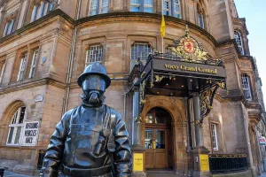 United Prints: Citizen Firefighter statue stands at entrance of Grand Central Hotel welcoming visitors in Glasgow