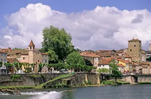 Sidewalk Prints: Cityscape of Cahors along the river with buildings, trees, and clouds in the sky in France