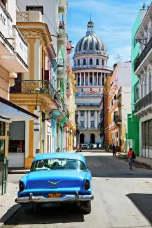Parliament Building Prints: A classic car parked on the street next to colonial buildings with the former Parliament