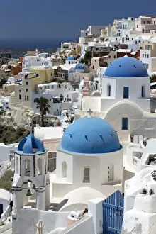 Cyclades Prints: Classic view of the village of Oia with its blue domed churches and colourful houses