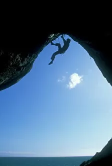 One Man Only Collection: A climber ascending a cave archway at Foxhole, Gower Peninsula, Wales, United Kingdom