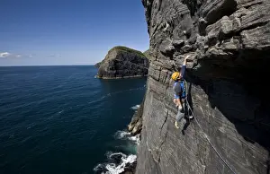 Strength Prints: A climber hangs above the sea on the huge west face of Dun Mingulay cliff