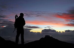 Silhouetted Gallery: A climber looks towards Mawenzi from near the summit of Mount Kilimanjaro at dawn