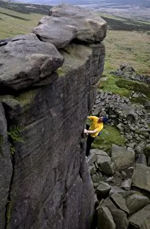 Climber makes a solo ascent of one of the thousands of classic outcrop climbs on the popular cliff of Stanage Edge