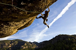 A climber tackles an exceptionally difficult, F8c graded, route on a big overhang at the cliffs of Margalef A climber tackles an exceptionally difficult, F8c graded, route on a big overhang at the cliffs of Margalef