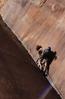 A climber tackles an overhanging corner on the cliffs of Indian Creek, a famous rock climbing area near Moab, Utah, United States of America