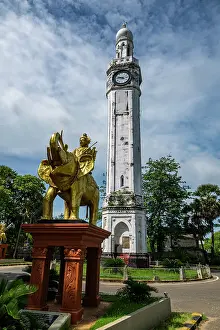 Elephant Prints: Clock tower stands tall in Jaffna as people pass by amidst greenery and blue skies in the Tamil region of Sri Lanka