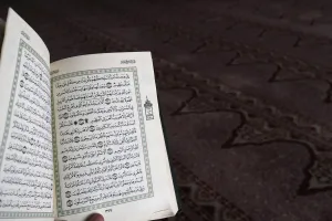 Quran Prints: Close up on hand with open Quran, Putra Mosque (Masjid Putra), Putrajaya, Malaysia